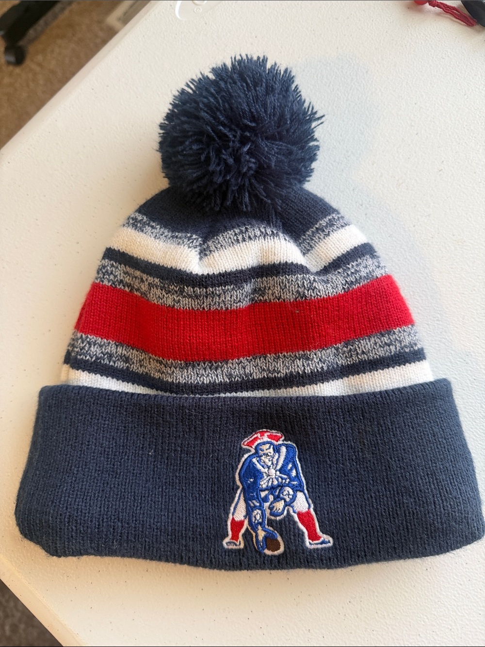 New England Patriots Navy Red Stripe Pom Beanie with Embroidered Football Logo